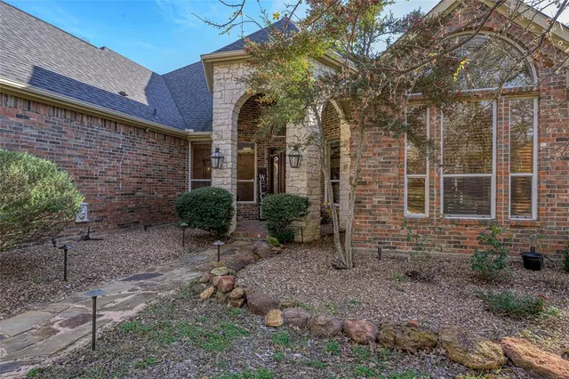a view of a brick house with many windows next to a yard