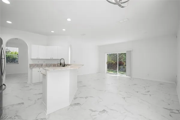 a view of kitchen with granite countertop cabinets and sink