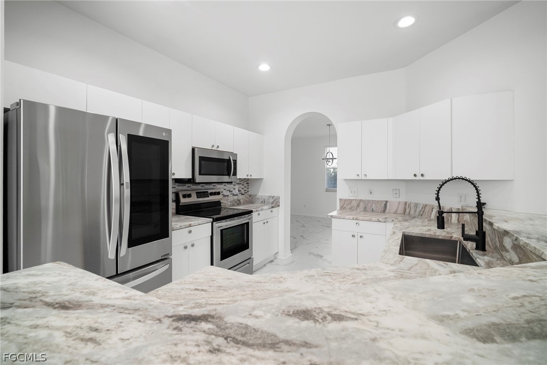 21768 Brixham Run Loop Estero, FL 33928 - Photo 13 of 36 a kitchen with stainless steel appliances a refrigerator sink and stove