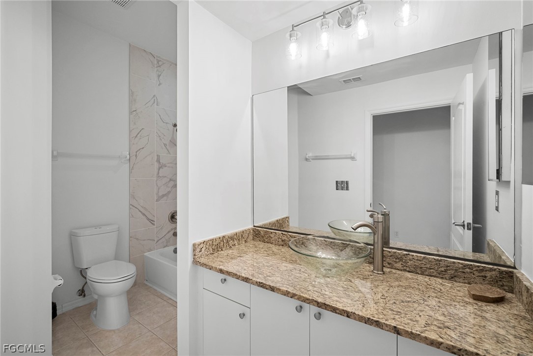 21768 Brixham Run Loop Estero, FL 33928 - Photo 16 of 36 a bathroom with a granite countertop sink a toilet and a mirror