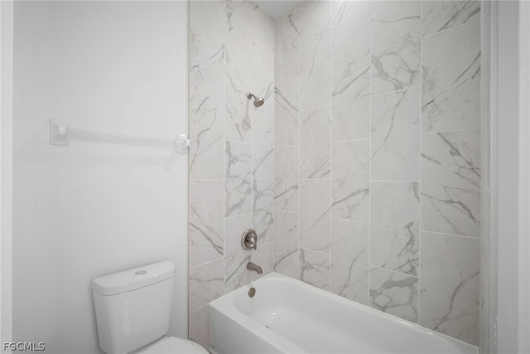 21768 Brixham Run Loop Estero, FL 33928 - Photo 17 of 36 a bathroom with a bathtub and toilet