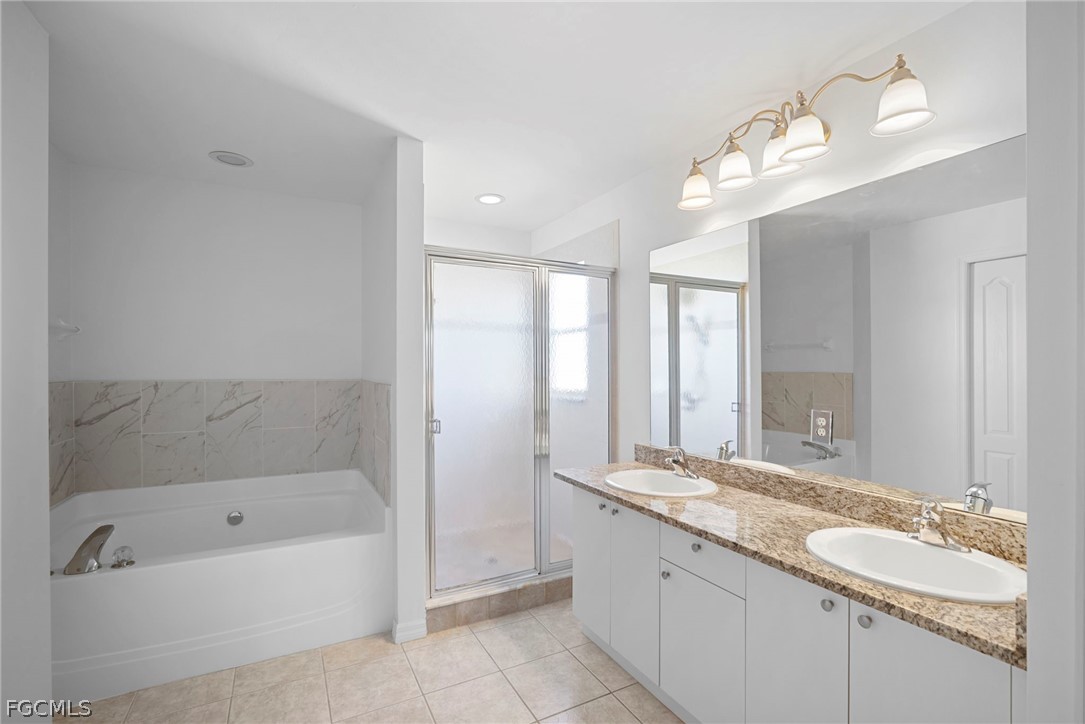 21768 Brixham Run Loop Estero, FL 33928 - Photo 27 of 36 a bathroom with a granite countertop bathtub a sink and a large mirror