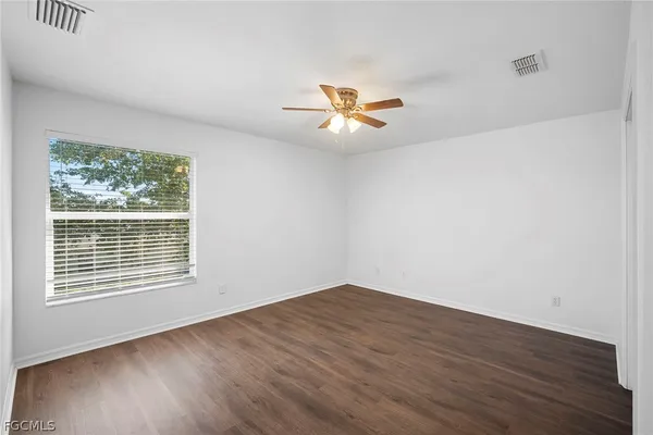 a view of a room with wooden floor and a ceiling fan