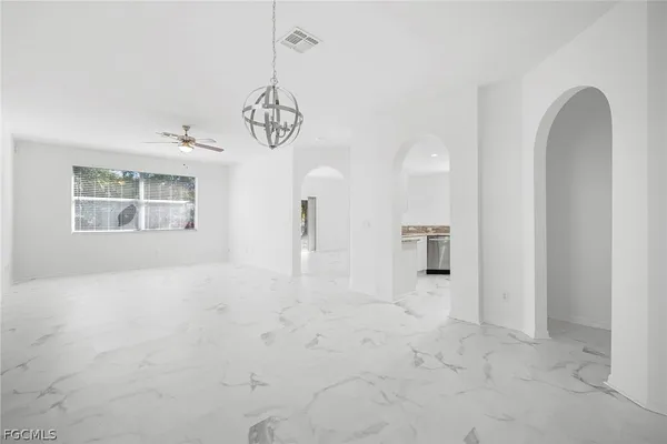 a view of a room with a chandelier fan and windows