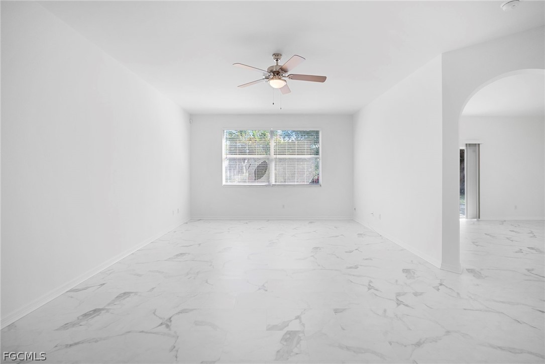 21768 Brixham Run Loop Estero, FL 33928 - Photo 6 of 36 an empty room with a chandelier fan and windows