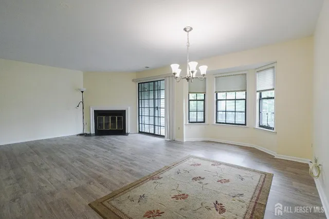 an empty room with windows and fireplace