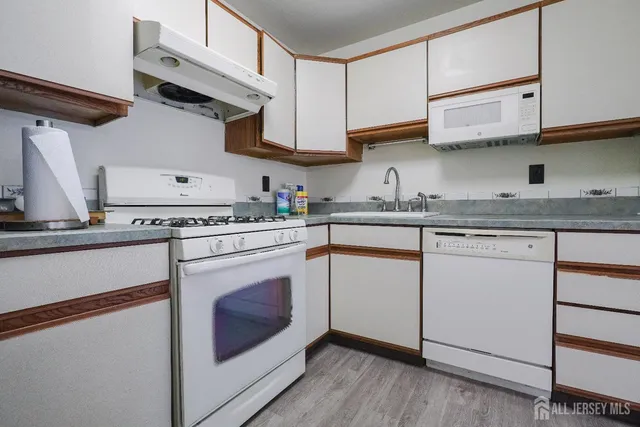 a kitchen with stainless steel appliances granite countertop a sink a stove and cabinets