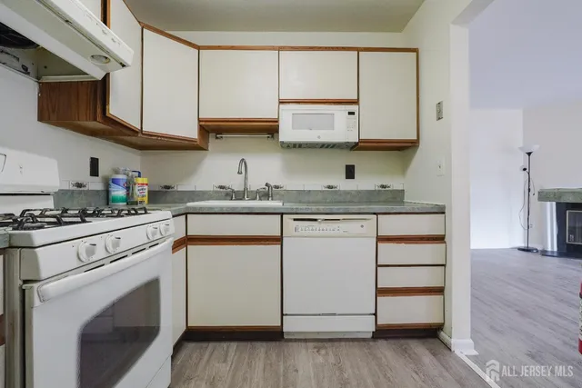 a kitchen with granite countertop wooden cabinets stainless steel appliances and a sink