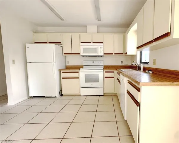 a kitchen with a stove a refrigerator and white cabinets