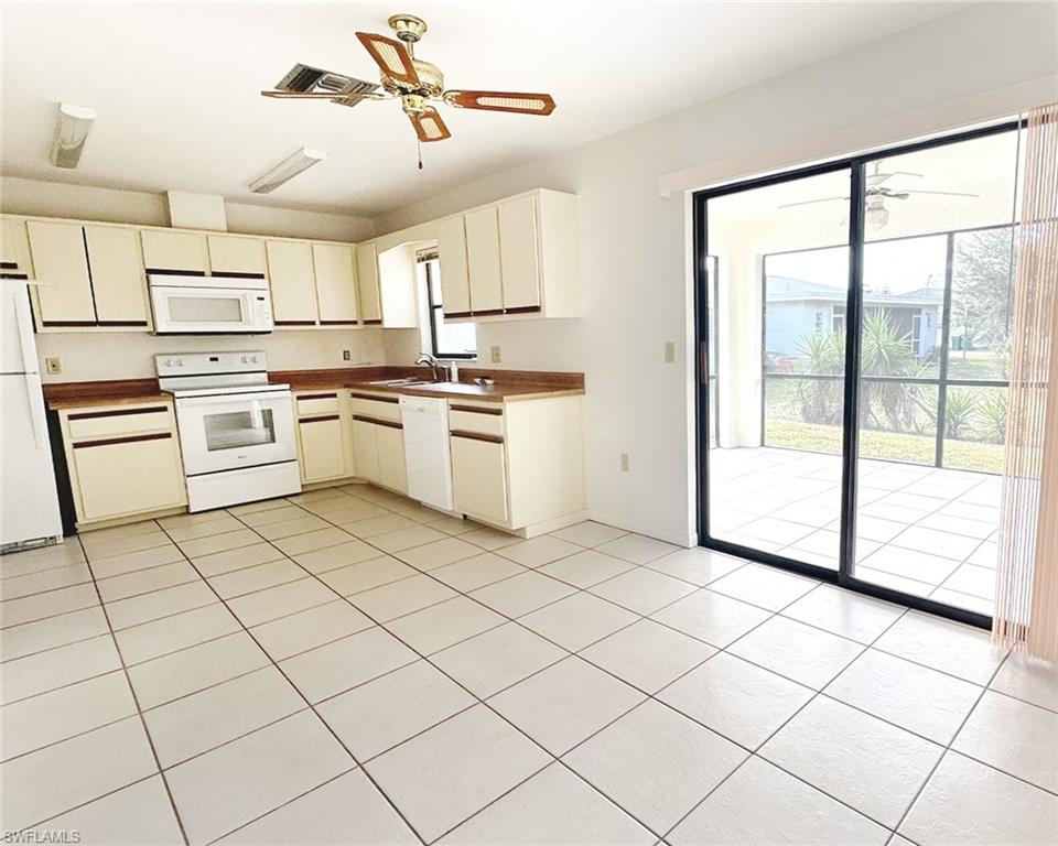 699 110th Avenue North, Unit B Naples, FL 34108 - Photo 8 of 23 a kitchen with a stove a sink and white cabinets