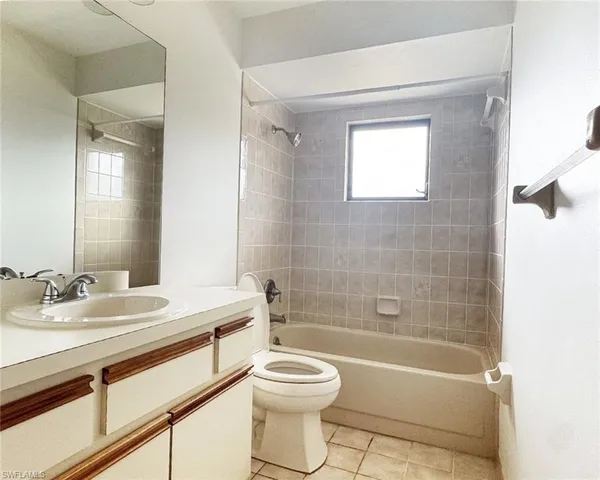 a spacious bathroom with a toilet sink and mirror