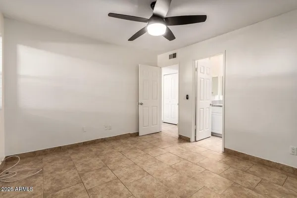 an empty room with closet and a chandelier fan
