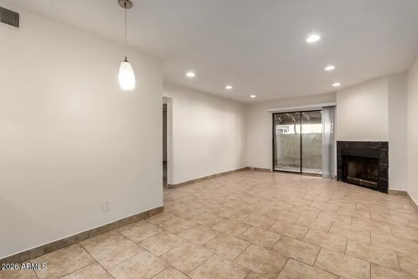 an empty room with windows and fireplace