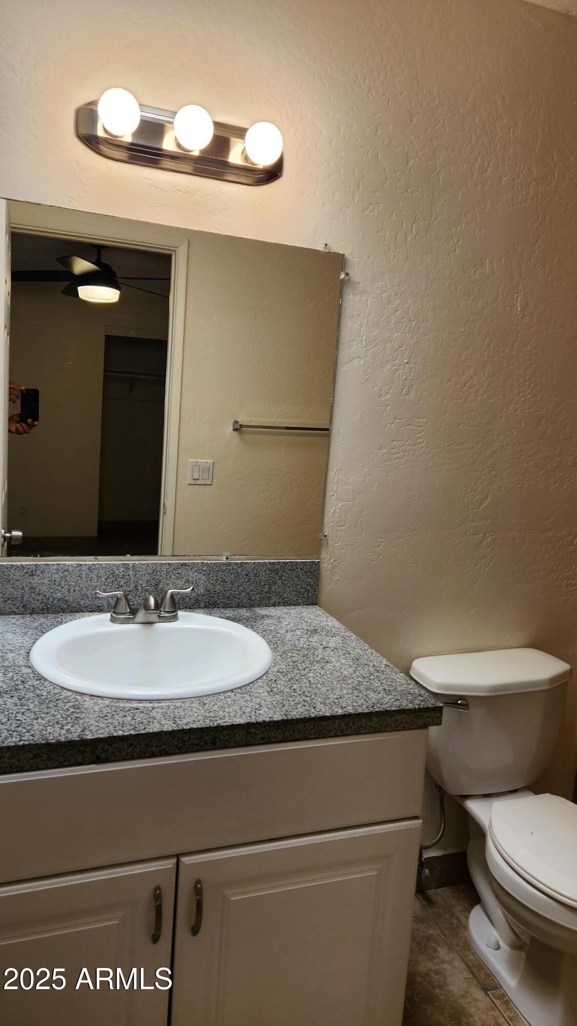 3119 North 38th Street, Unit 10 Phoenix, AZ 85018 - Photo 15 of 20 a bathroom with a granite countertop toilet sink and mirror