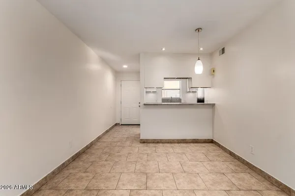 a view of kitchen with white cabinets and counter space