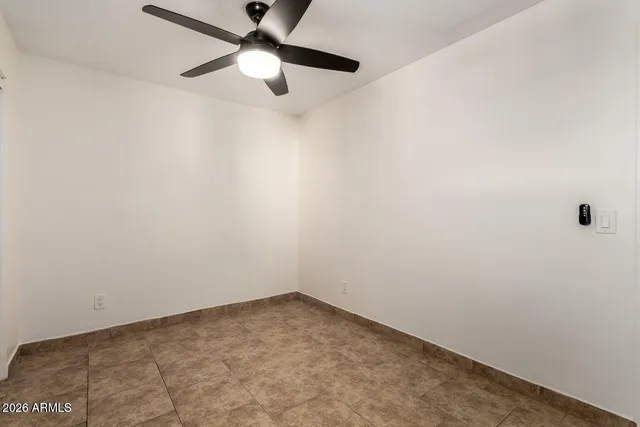 an empty room with a window and a fan