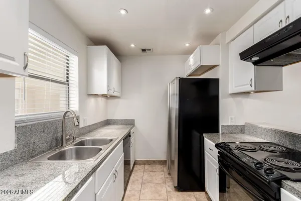 a kitchen with kitchen island granite countertop a sink and a stove