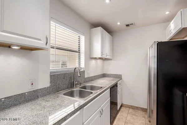 a kitchen with stainless steel appliances granite countertop a sink and a refrigerator