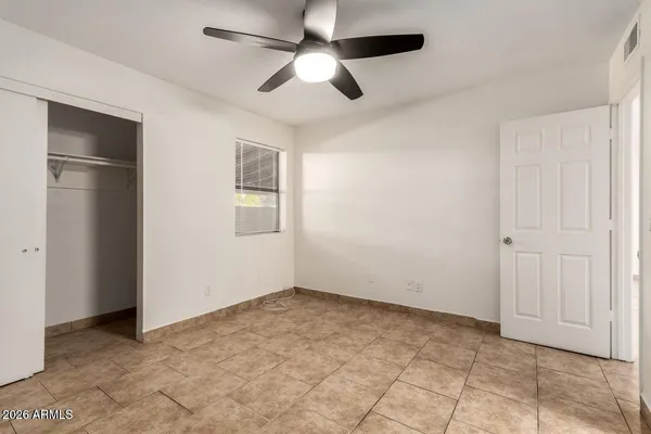 a view of an empty room with a ceiling fan