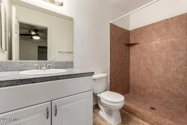 a bathroom with a granite countertop sink toilet and shower