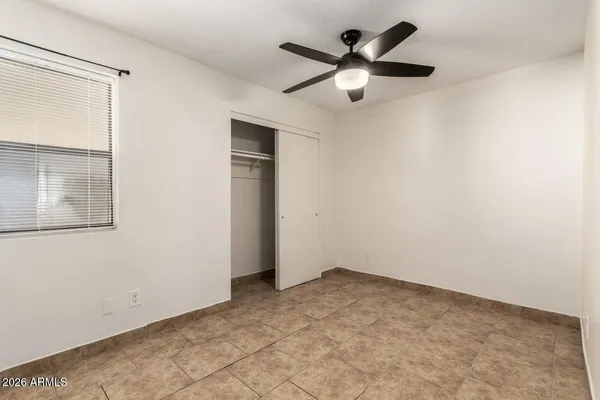 an empty room with closet and windows