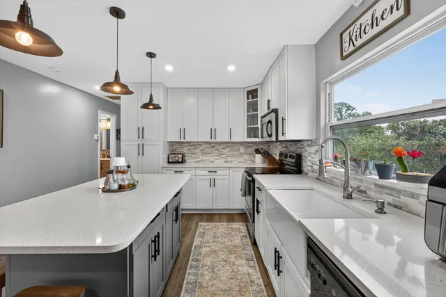 a view of a house with a yard and large tree