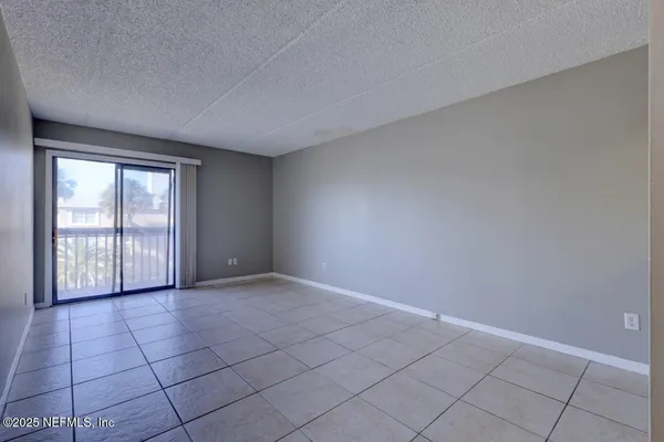 a view of a kitchen with a sink and an empty room