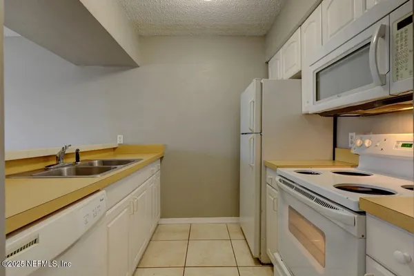 a kitchen with a refrigerator and a stove