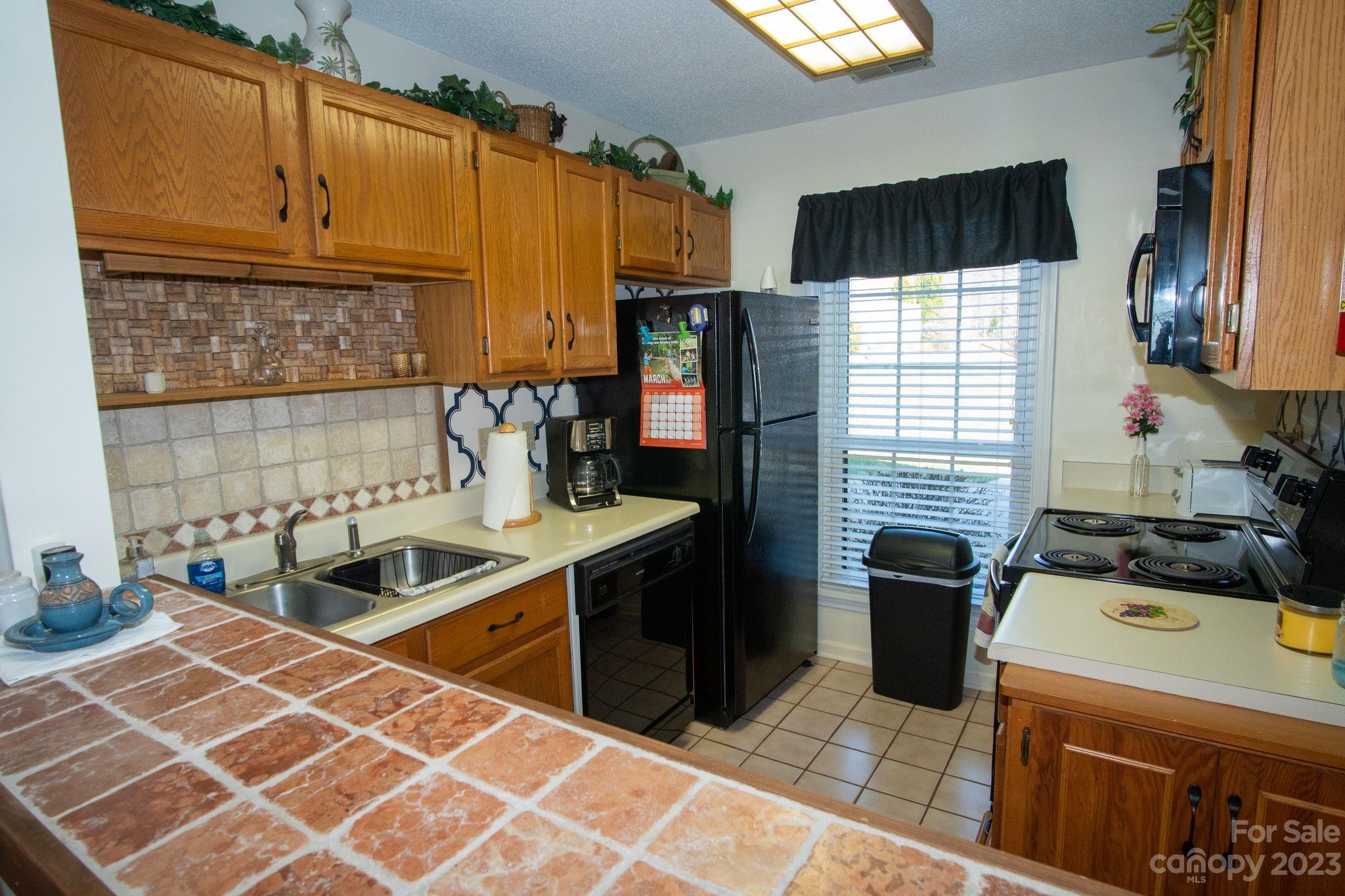 2881 White Oak Mountain Road, Unit D2 Columbus, NC 28722 - Photo 22 of 39 a kitchen with stainless steel appliances granite countertop a sink stove and refrigerator