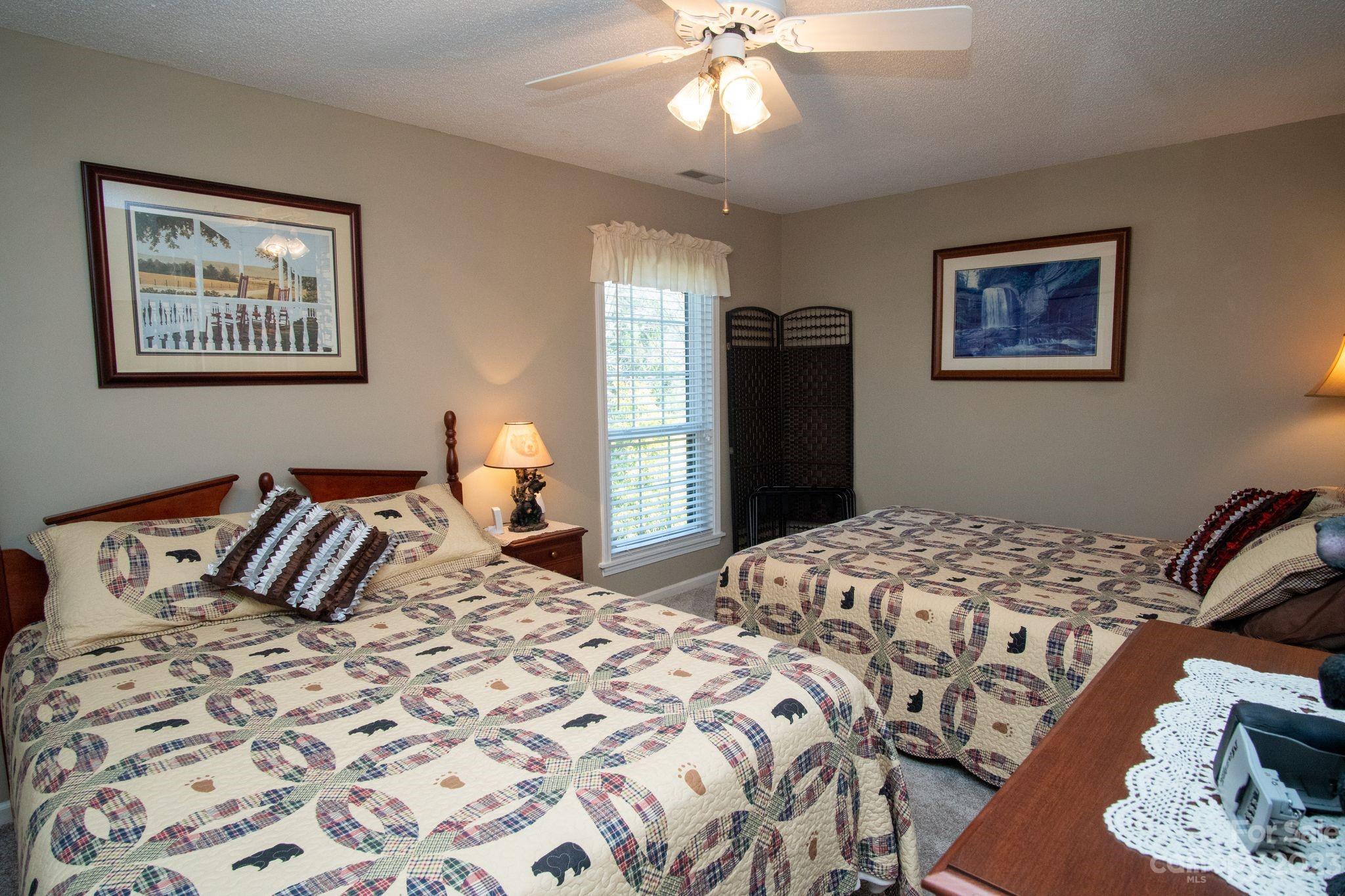 2881 White Oak Mountain Road, Unit D2 Columbus, NC 28722 - Photo 36 of 39 a bedroom with a large bed and a chandelier