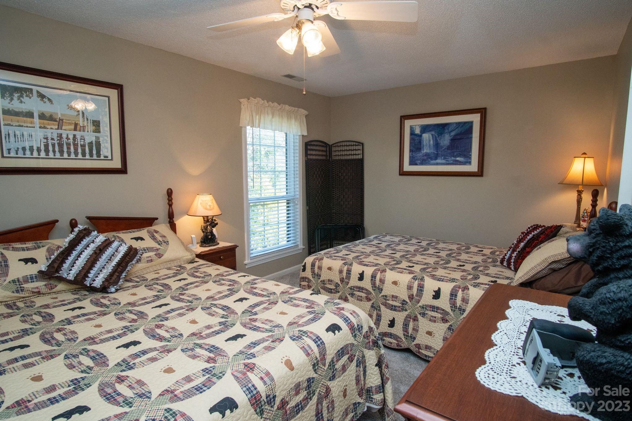 2881 White Oak Mountain Road, Unit D2 Columbus, NC 28722 - Photo 37 of 39 a bedroom with a large bed and a chandelier