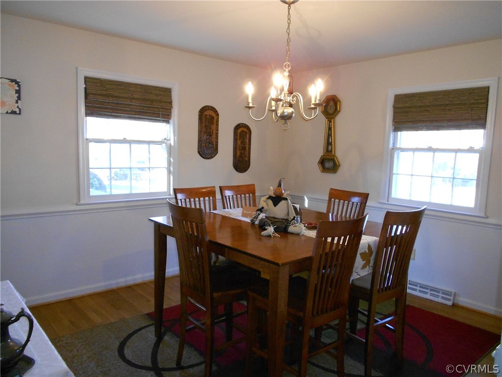 11019 Rockledge Road Richmond, VA 23235 - Photo 14 of 36 a view of a dining room with furniture a chandelier and wooden floor