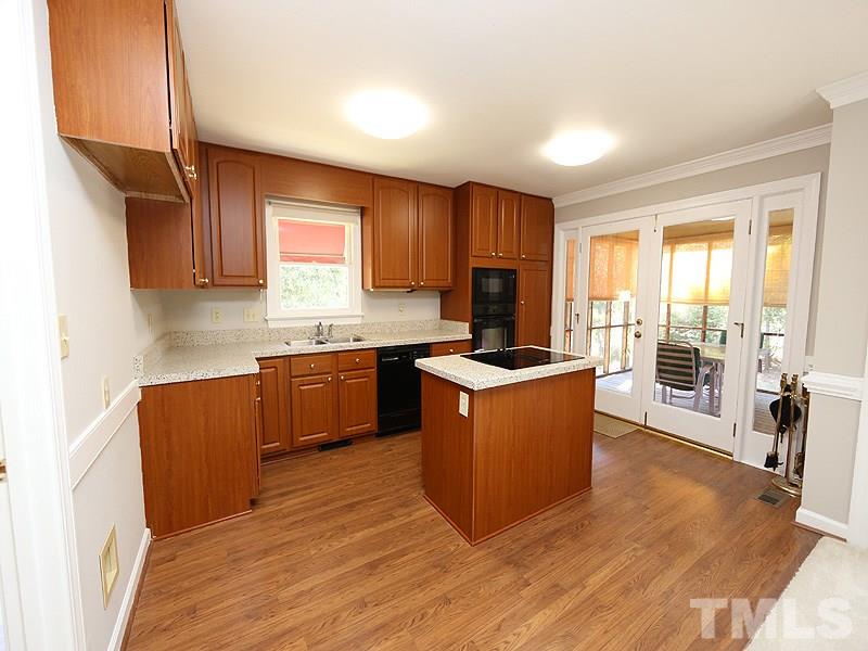 7621 Pinewild Court Raleigh, NC 27615 - Photo 6 of 14 a kitchen with stainless steel appliances kitchen island wooden cabinets a stove a sink a refrigerator and cabinets