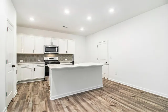 a kitchen with cabinets and wooden floor