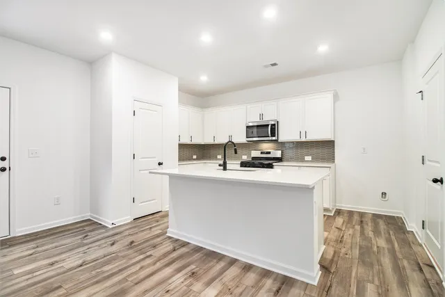 a kitchen with stainless steel appliances a refrigerator and a stove top oven