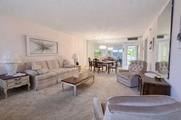 a living room with furniture and a view of kitchen