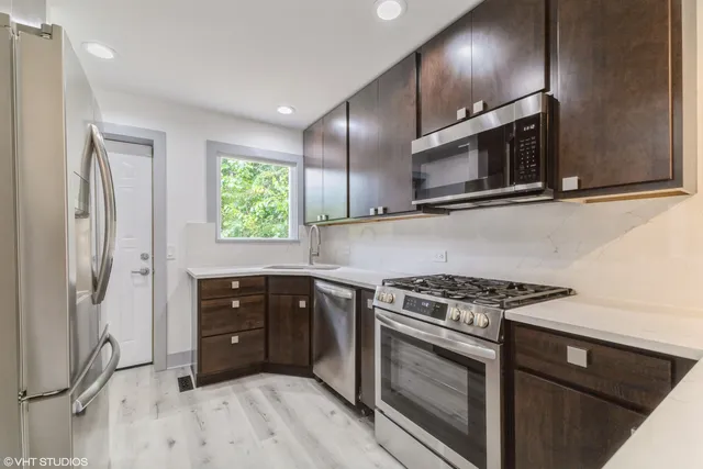 a kitchen with stainless steel appliances granite countertop a stove a microwave and a refrigerator