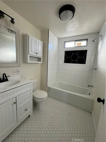 a bathroom with a toilet a sink a mirror and a bathtub