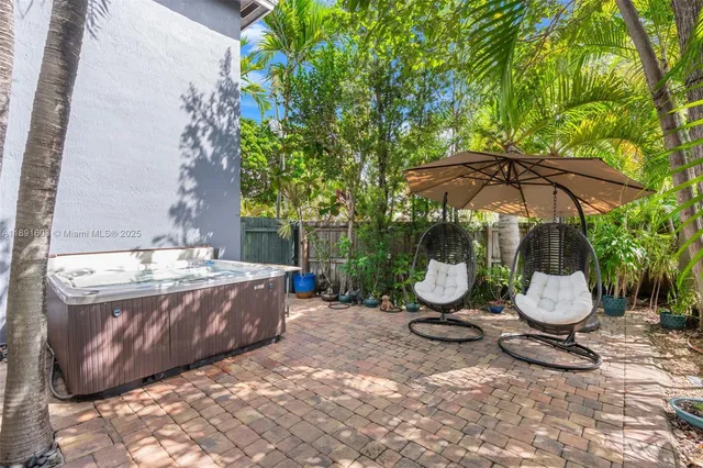 a view of a backyard with plants and a tub