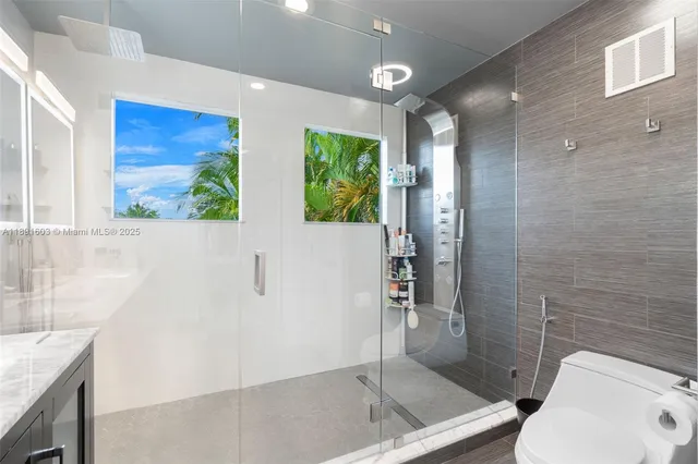 a bathroom with a granite countertop sink a toilet and shower