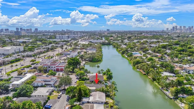 an aerial view of residential houses with outdoor space and lake view