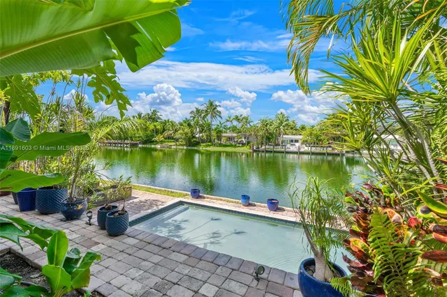 a view of a lake with a floor to ceiling window next to a yard