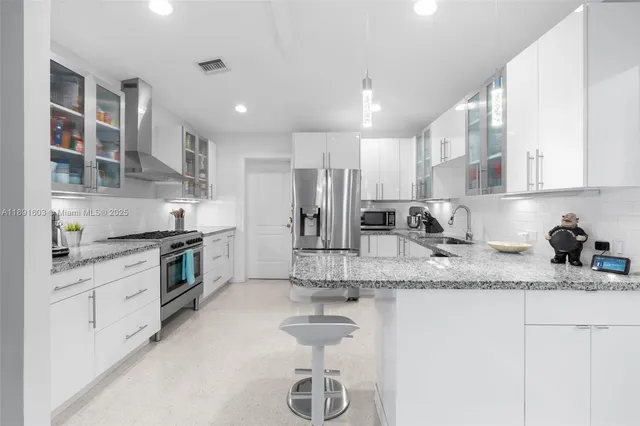 a kitchen with stainless steel appliances granite countertop a sink stove and refrigerator