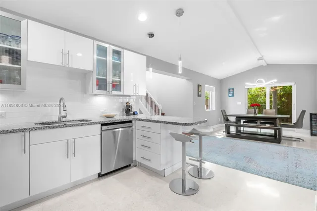 a kitchen with stainless steel appliances granite countertop a sink a stove and a wooden floors