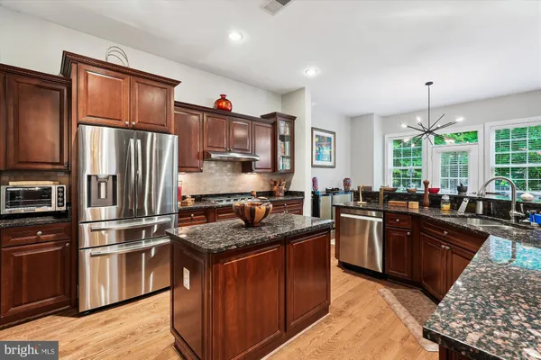 a kitchen with stainless steel appliances white cabinets and a refrigerator