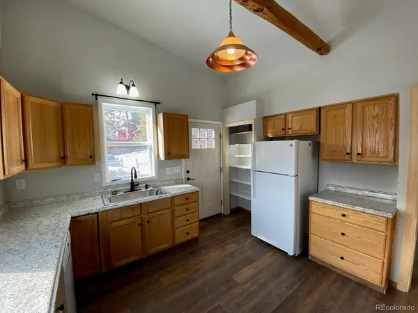 a kitchen with a refrigerator and a stove top oven