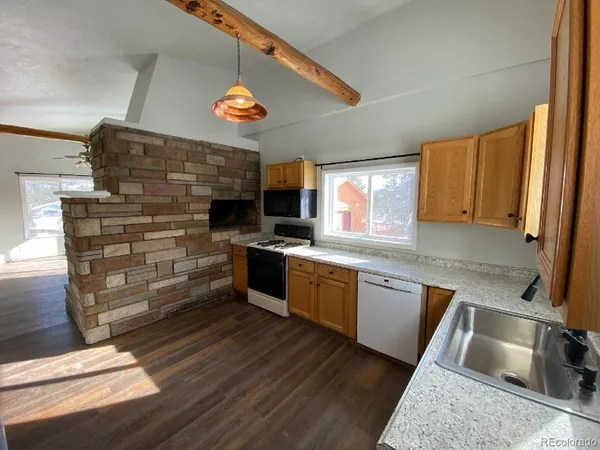 a kitchen with stainless steel appliances kitchen island granite countertop a stove a sink and a microwave