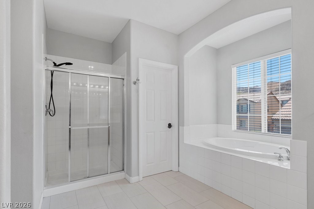 10336 Hawk Ravine Street Las Vegas, NV 89178 - Photo 30 of 59 This bathroom features a soaking tub and a spacious glass-enclosed shower.