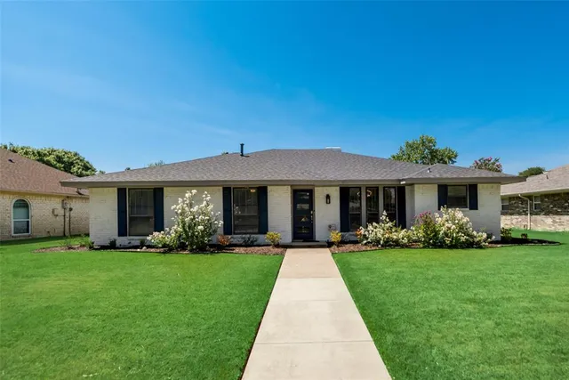 a front view of a house with a yard and trees