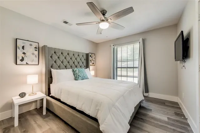 a bed room with a bed dresser and a flat screen tv